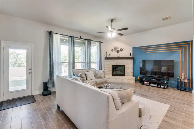 a living room with furniture a fireplace and a flat screen tv
