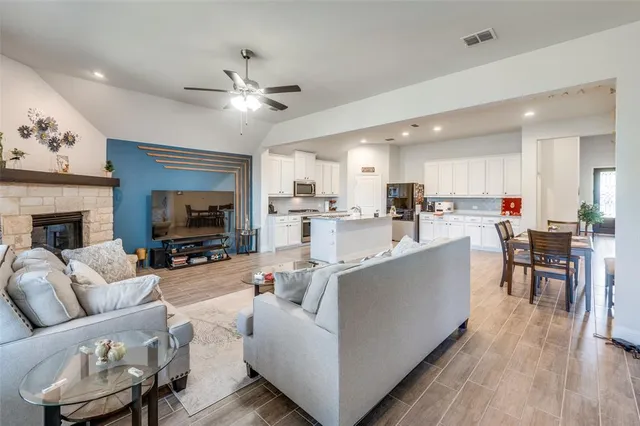 a living room with furniture a fireplace and a flat screen tv