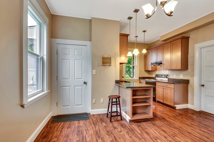 56 Warren Avenue, Unit R Woburn, MA 01801 - Photo 5 of 5 a kitchen with stainless steel appliances granite countertop a refrigerator a sink dishwasher a stove and white countertops with wooden floor