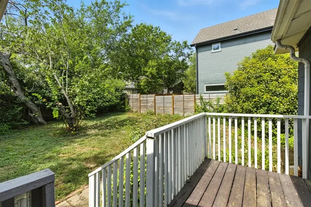 a view of a wooden deck and yard with green space