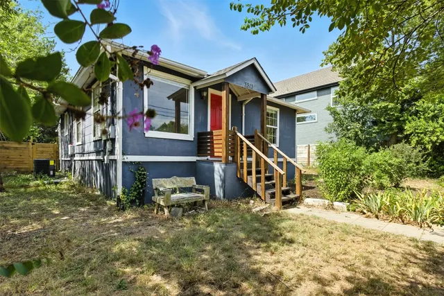 a view of a house with a yard and potted plants