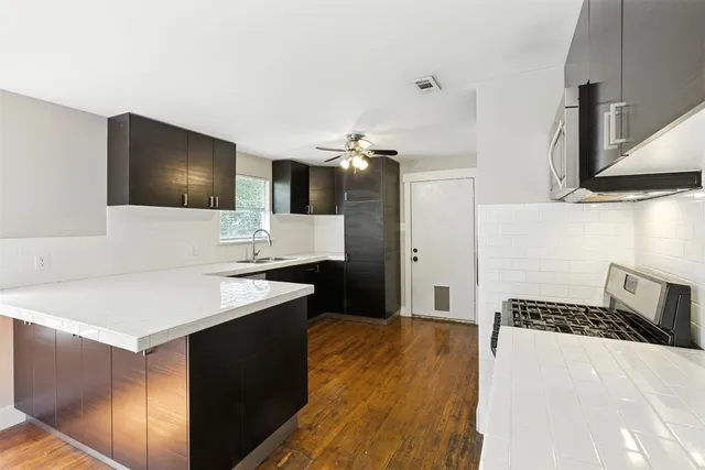 a kitchen with a sink appliances and cabinets