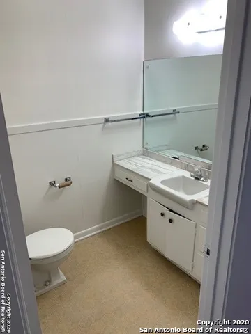 a bathroom with a sink a toilet and a mirror