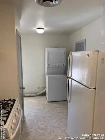 a white refrigerator freezer and a stove sitting inside of a kitchen