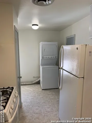 a white refrigerator freezer and a stove sitting inside of a kitchen