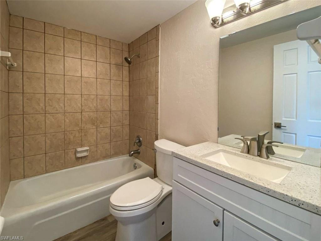 550 14th Street North Naples, FL 34102 - Photo 15 of 21 a bathroom with a granite countertop toilet a sink and bathtub