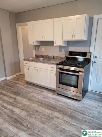 a kitchen with granite countertop wooden cabinets stainless steel appliances and a sink