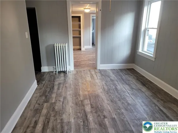 a view of a hallway with wooden floor and staircase