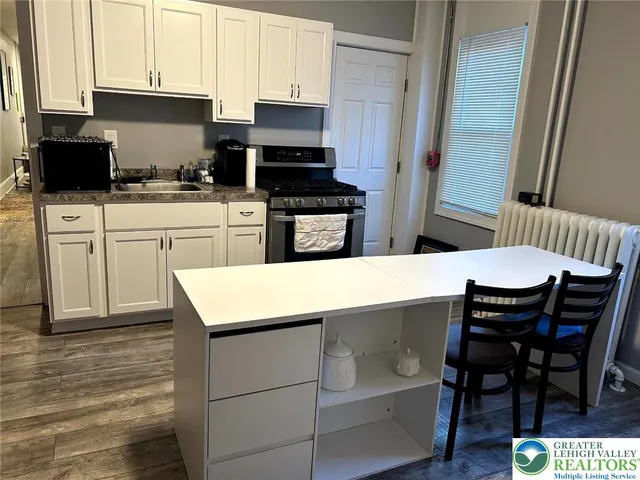 a kitchen with a sink a microwave and cabinets