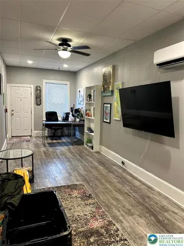 a living room with stainless steel appliances kitchen island furniture and a wooden floor