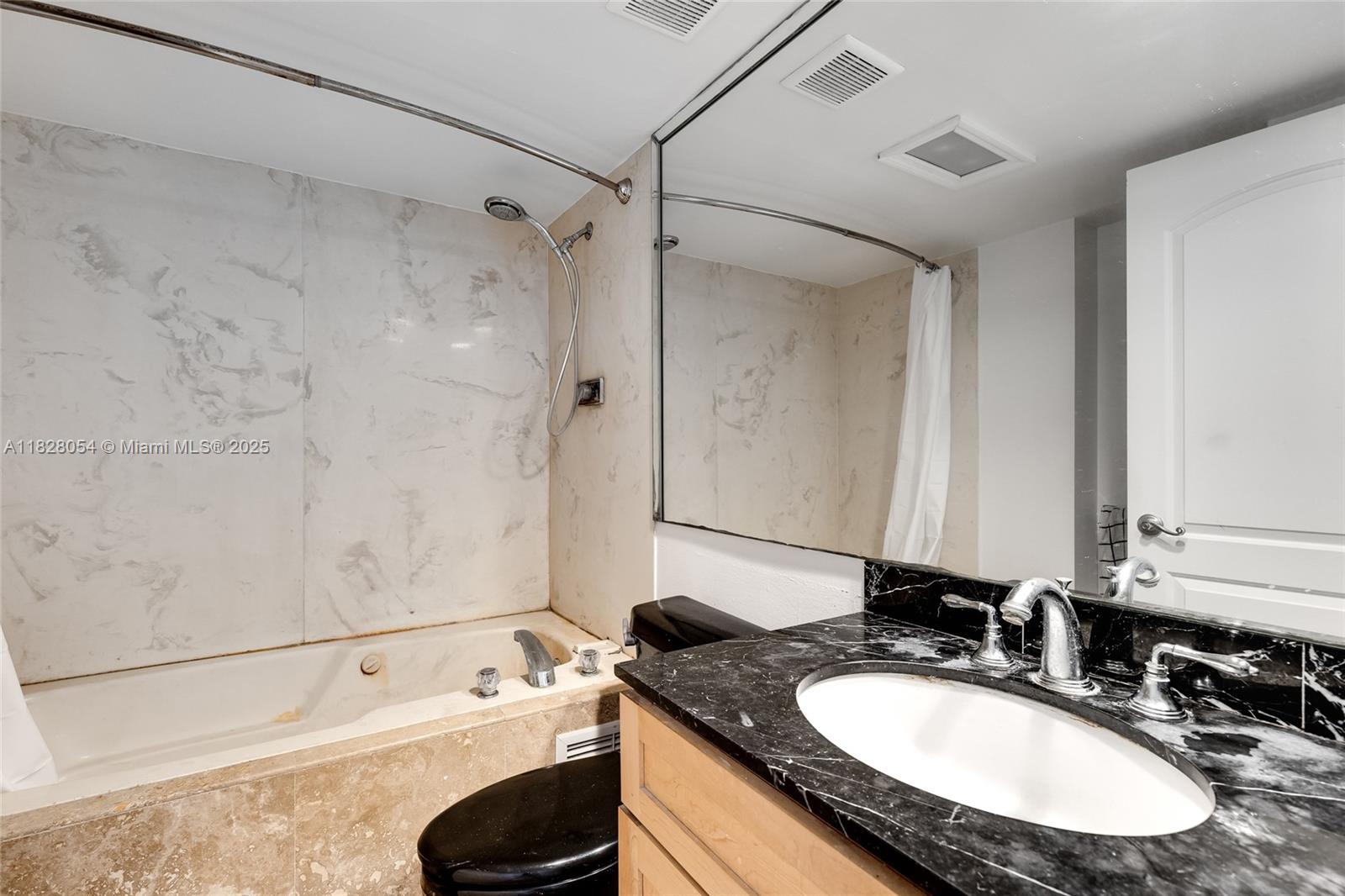 520 Brickell Key Drive, Unit A1817 Miami, FL 33131 - Photo 14 of 20 a bathroom with a granite countertop sink a mirror and a bathtub