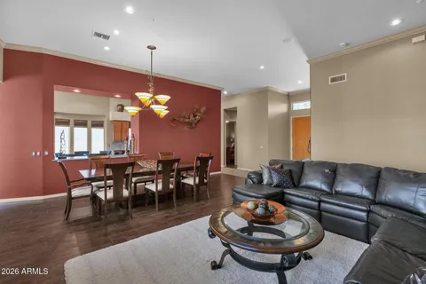 a living room with furniture a dining table and a chandelier