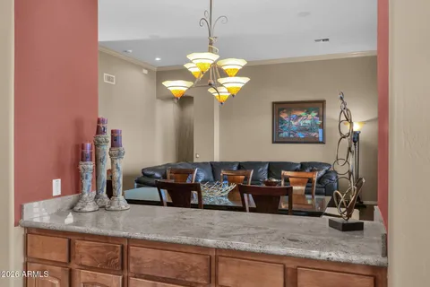 a living room with kitchen island granite countertop furniture and a chandelier