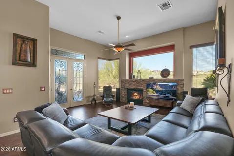 a living room with furniture a large window and a chandelier