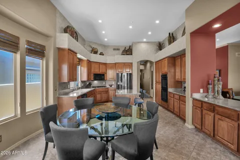 a dining room with furniture a large window and stainless steel appliances