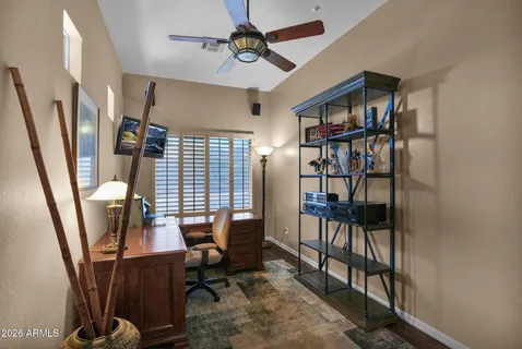 a view of a workspace with furniture and a window