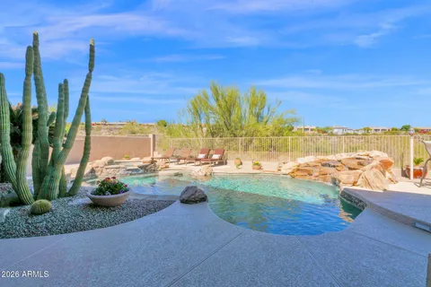 a view of a swimming pool with a lawn chairs under an umbrella