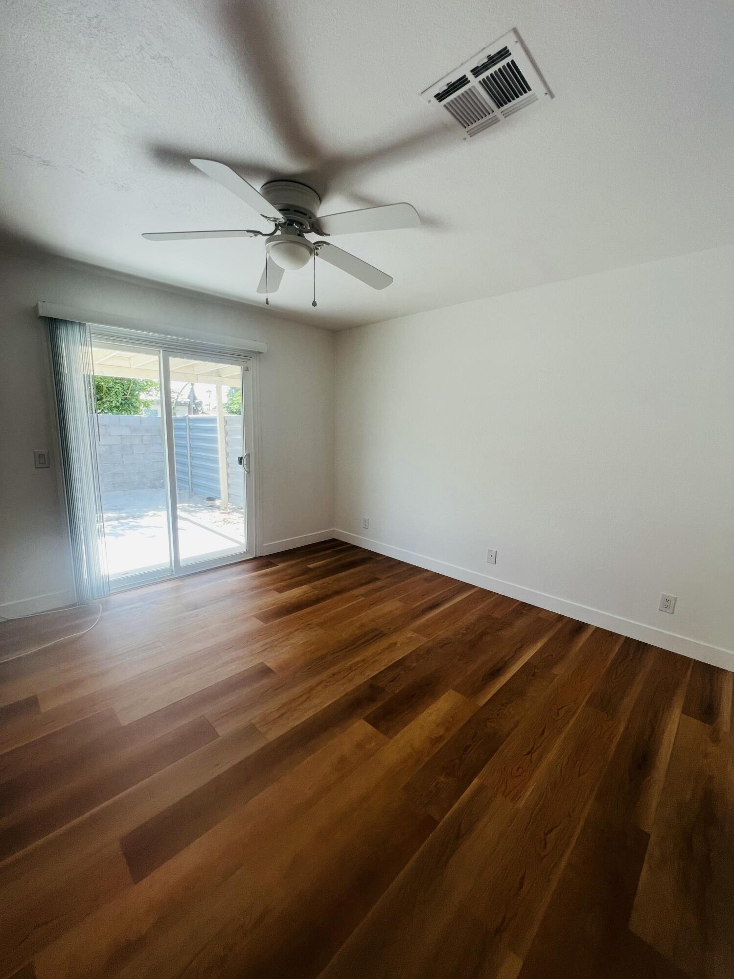 32900 Monte Vista Road Cathedral City, CA 92234 - Photo 14 of 18 an empty room with wooden floor fan and windows