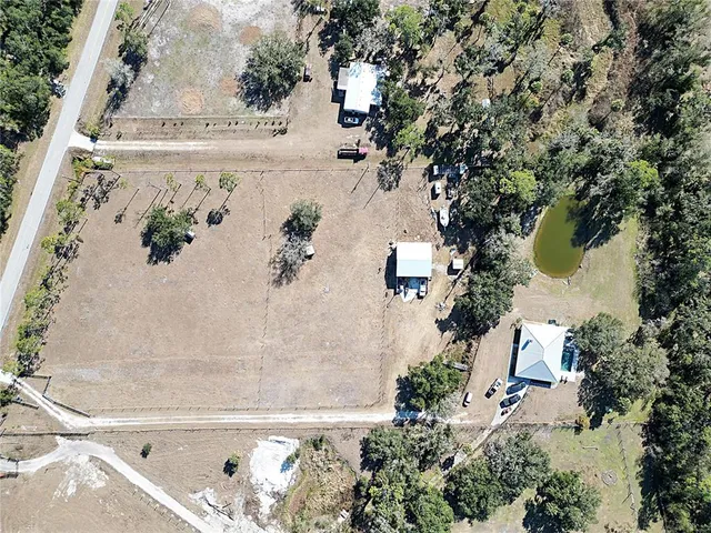 an aerial view of a house with a backyard and trees