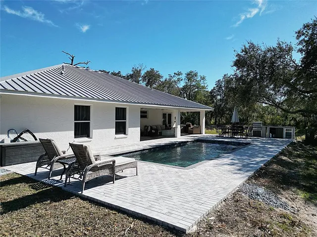 a view of a house with swimming pool and sitting area