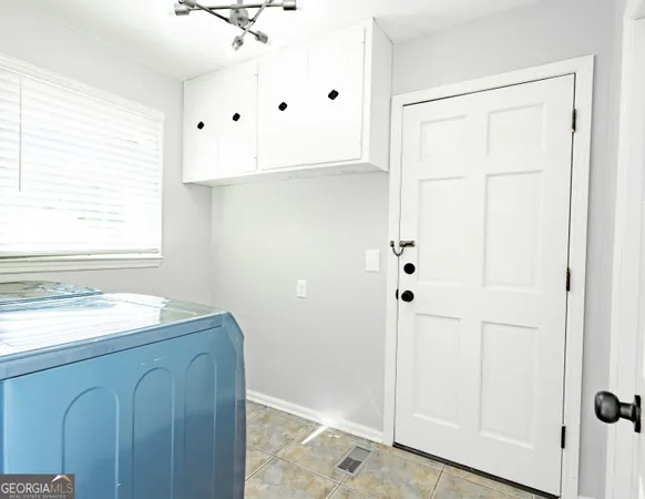 a living room with couches and kitchen view with wooden floor