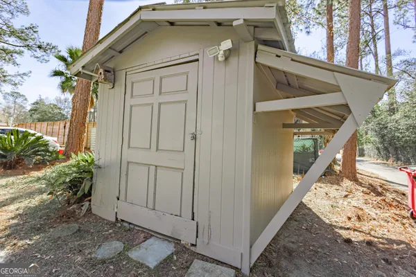 an empty room with wooden floor cabinet and windows