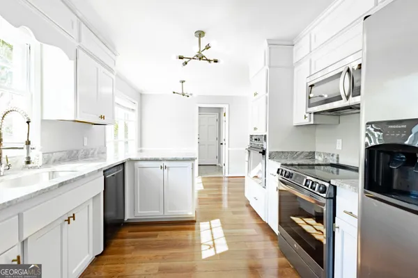 a kitchen with stainless steel appliances granite countertop a stove sink and cabinets