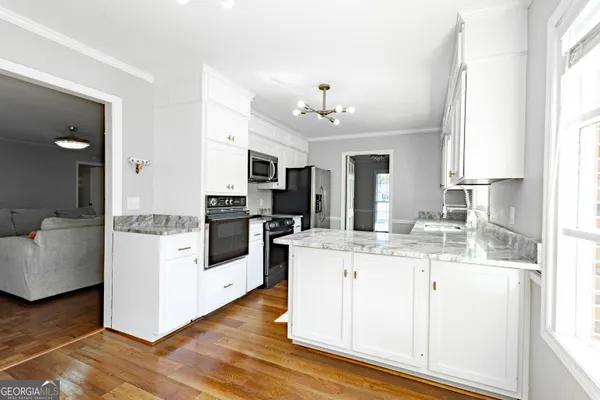 a kitchen with stainless steel appliances kitchen island granite countertop a refrigerator and a stove top oven