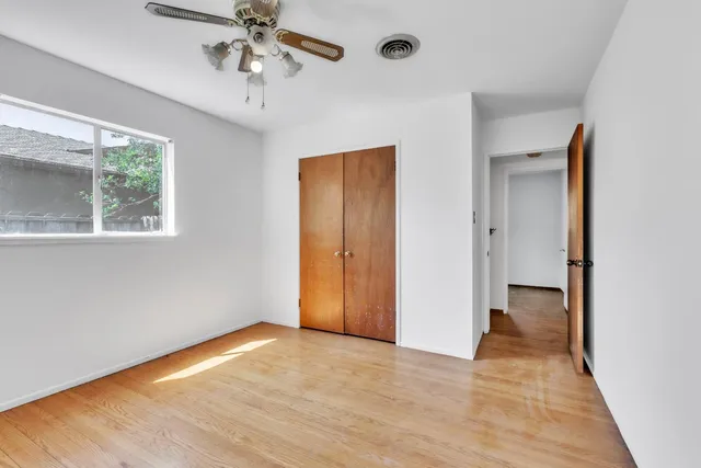 a view of a livingroom with a chandelier fan and a window
