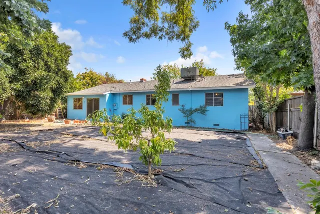 a view of a house with a yard and a tree