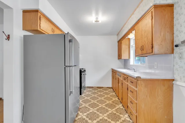 a kitchen with stainless steel appliances granite countertop a refrigerator and a sink