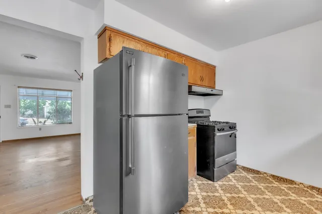 a metallic refrigerator freezer sitting in a kitchen