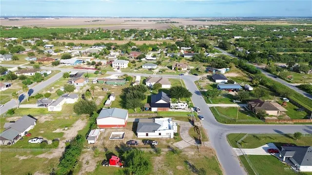 an aerial view of residential houses with outdoor space and trees