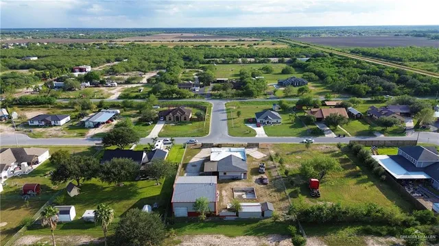 an aerial view of residential houses with outdoor space and trees