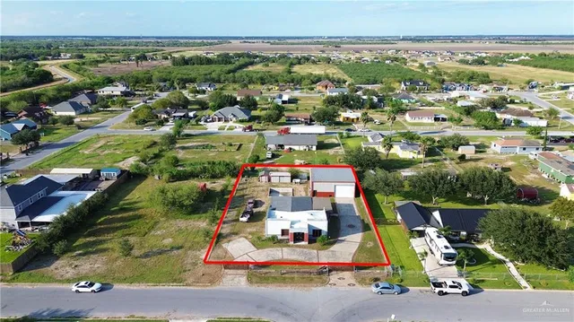 an aerial view of residential houses with outdoor space and parking
