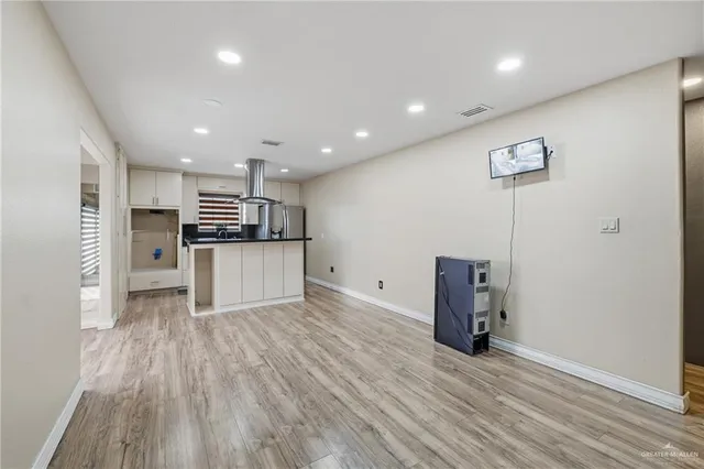 a view of kitchen with stainless steel appliances a refrigerator and wooden floor