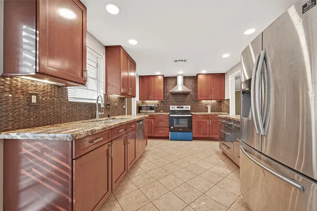 a kitchen with stainless steel appliances granite countertop a refrigerator and a sink