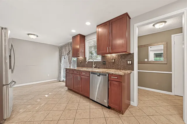 a kitchen with stainless steel appliances granite countertop a refrigerator and a sink