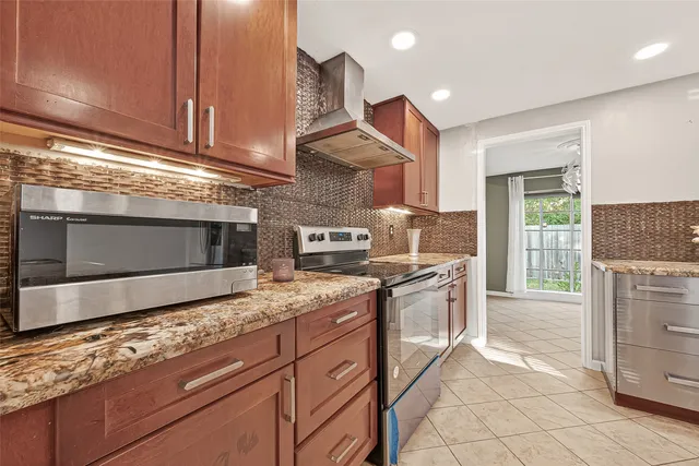 a kitchen with stainless steel appliances granite countertop a stove a sink and a microwave
