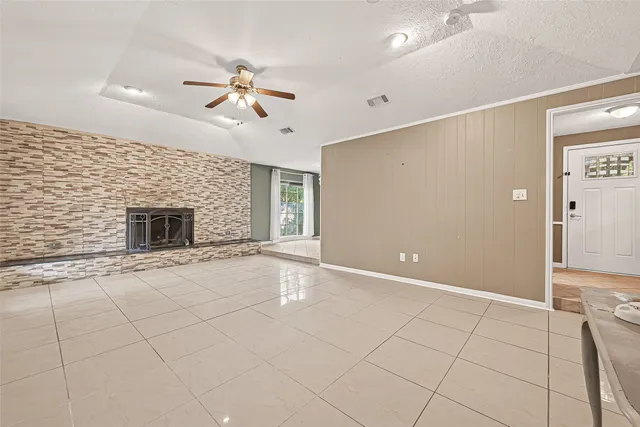 an empty room with windows and fireplace