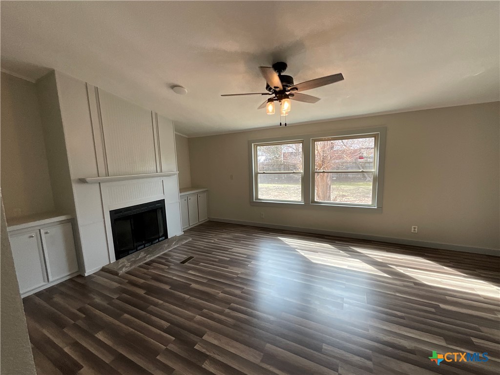 2301 Sumac Lane Cedar Park, TX 78613 - Photo 14 of 26 a view of a livingroom with a fireplace a ceiling fan and windows