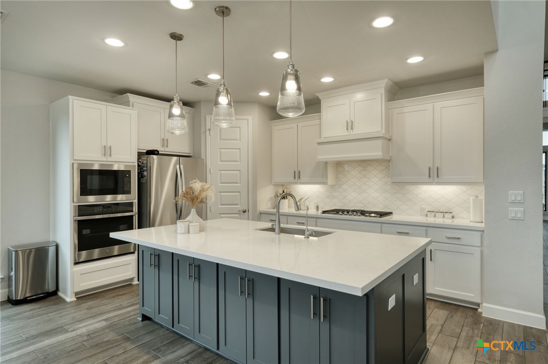 1401 Mulberry Oak Lane Georgetown, TX 78628 - Photo 11 of 30 Kitchen featuring appliances with stainless steel finishes, a sink, white cabinets, and recessed lighting.