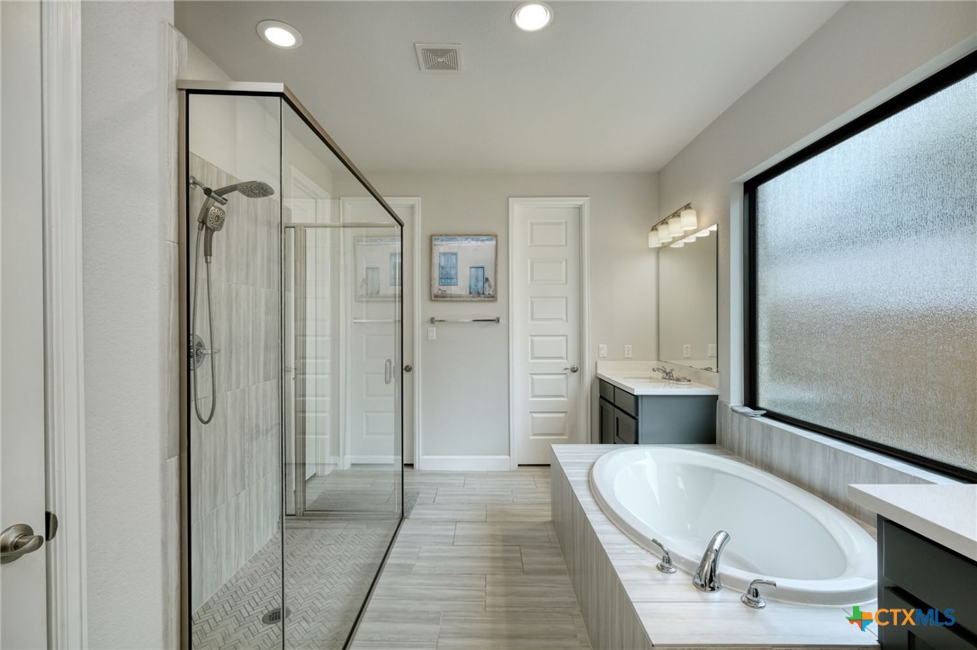 1401 Mulberry Oak Lane Georgetown, TX 78628 - Photo 15 of 30 Bathroom featuring a shower stall, a garden tub, vanity, recessed lighting, and baseboards
