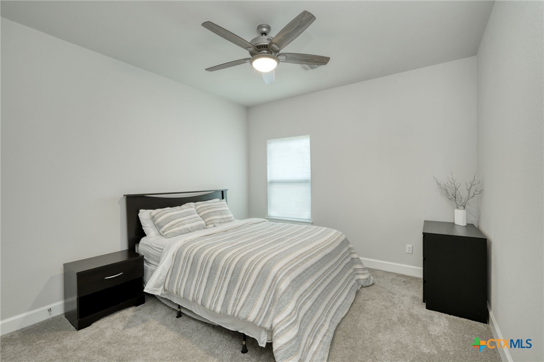 1401 Mulberry Oak Lane Georgetown, TX 78628 - Photo 20 of 29 a bedroom with a bed and a ceiling fan