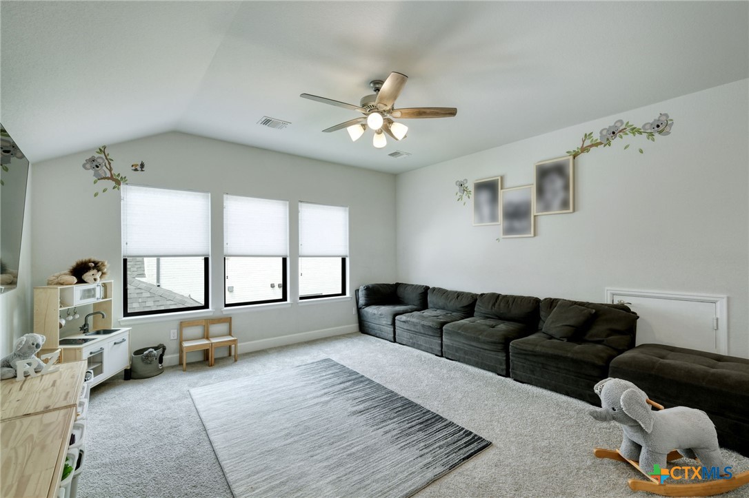 1401 Mulberry Oak Lane Georgetown, TX 78628 - Photo 20 of 30 Living area featuring a ceiling fan, carpet, lofted ceiling, and baseboards