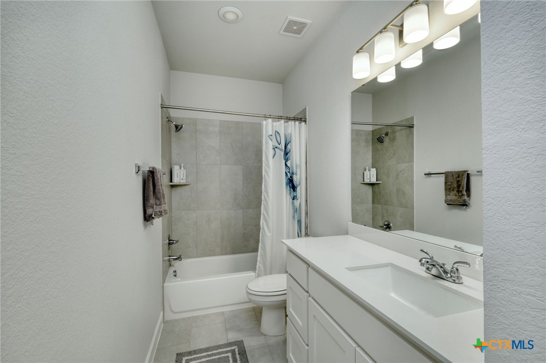 1401 Mulberry Oak Lane Georgetown, TX 78628 - Photo 23 of 30 Full bath with tile patterned floors, shower / bath combo, toilet, and vanity