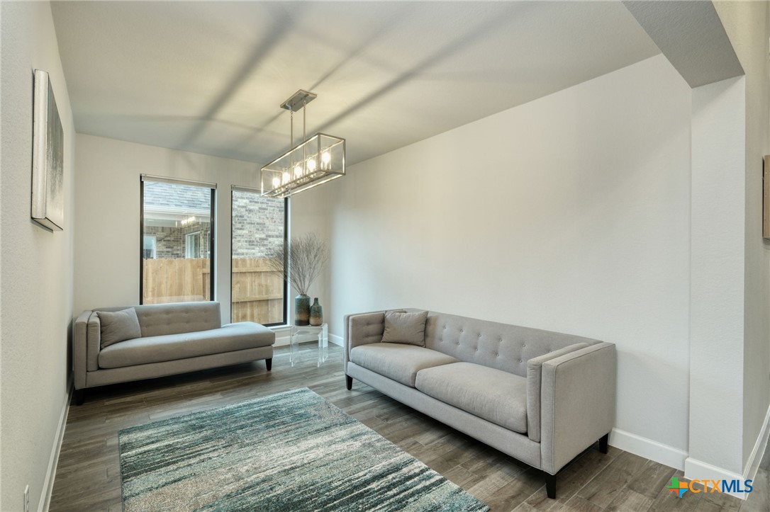 1401 Mulberry Oak Lane Georgetown, TX 78628 - Photo 7 of 30 Serves as one of the living spaces, complete with baseboards, a chandelier, and wood-finished flooring