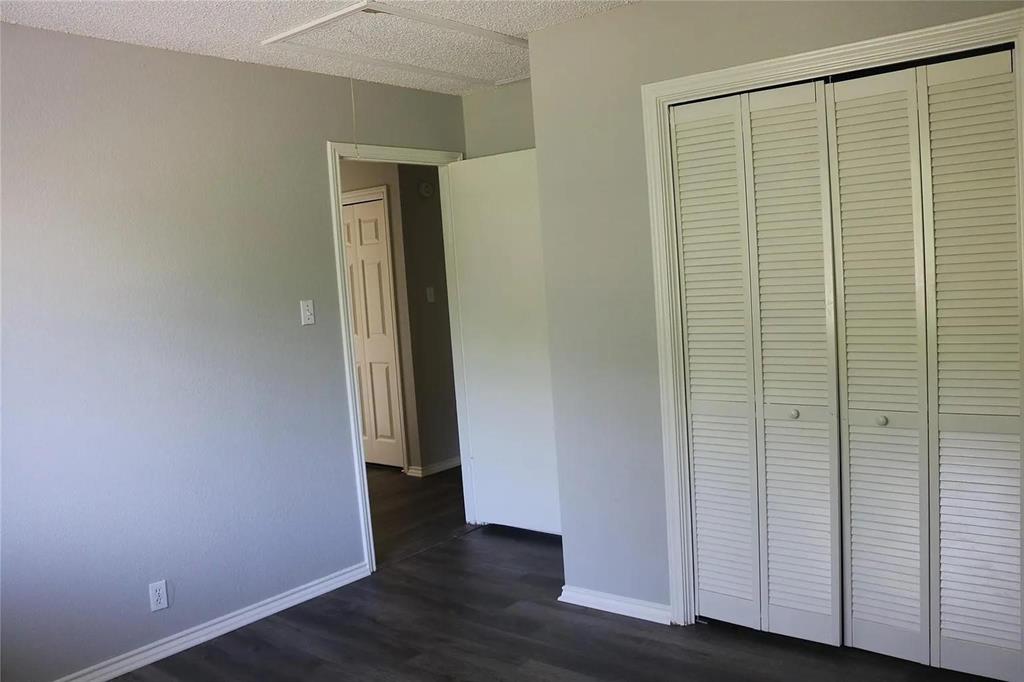 627 Cherry Lane Southlake, TX 76092 - Photo 15 of 19 Unfurnished bedroom with dark wood-style flooring, a closet, and a textured ceiling