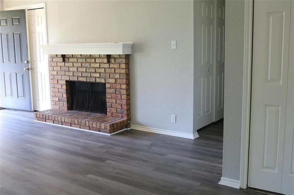 627 Cherry Lane Southlake, TX 76092 - Photo 9 of 19 Unfurnished living room with dark wood-style floors and a fireplace