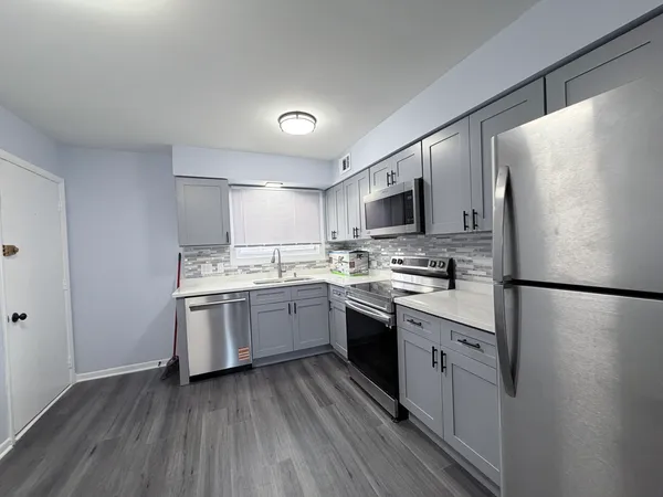 a kitchen with granite countertop a refrigerator stove top oven and sink